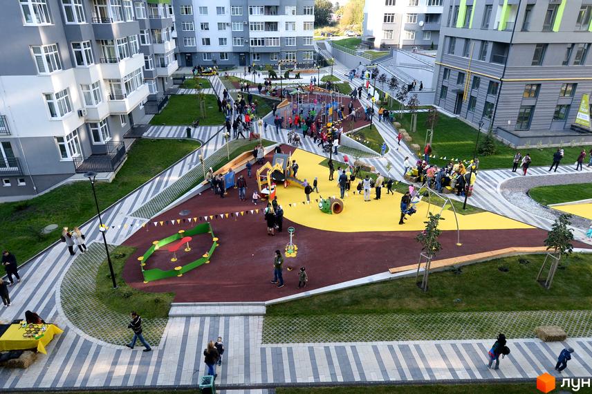 Житловий комплекс Пасічний: сучасний комплекс з дитячим майданчиком та зонами відпочинку. Огляд території новобудови з людьми.