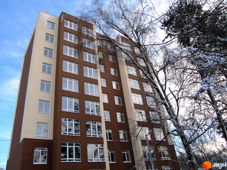 Висотна будівля ЖК Green Life-2 з великою кількістю вікон. Поруч засніжені дерева, що додають зимового настрою.