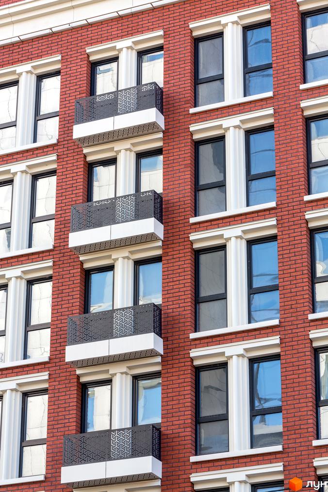 Фасад цегляного будинку з балконами в Житловому комплексі New York Concept House. Вікна з білим обрамленням.
