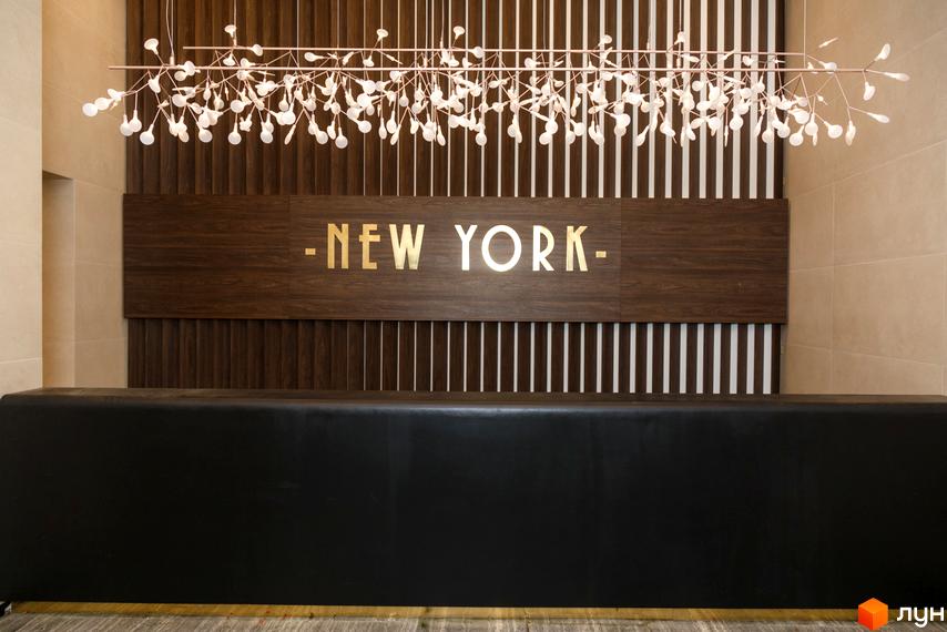 Ресепшн в Житловому комплексі New York Concept House. Інтер'єр з дерев'яними панелями та освітленням, стійка реєстрації.
