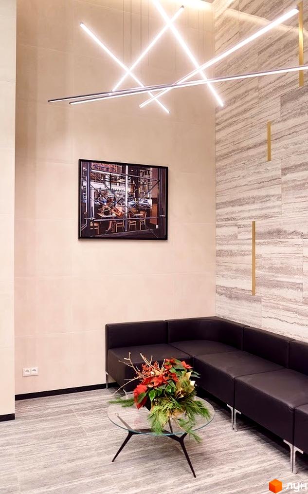 Інтер'єр з диваном, журнальним столиком та картиною в Житловому комплексі New York Concept House. Освітлення та декоративні елементи.