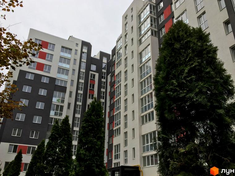 Житловий комплекс Контраст: багатоповерхові будинки з контрастним фасадом, вікнами та зеленими деревами. Зовнішній вигляд новобудови.