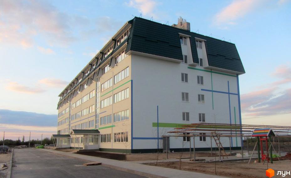 Житловий комплекс Милі квартири – білий п'ятиповерховий будинок із зеленим дахом та декоративними смугами. Біля будинку розташований дитячий майданчик.