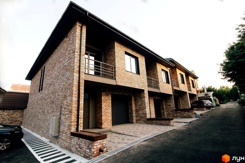 Зображення таунхаусів «Гагарінський». Двоповерхові будинки з цегли з балконами та гаражами, перед будинками вимощена бруківка.