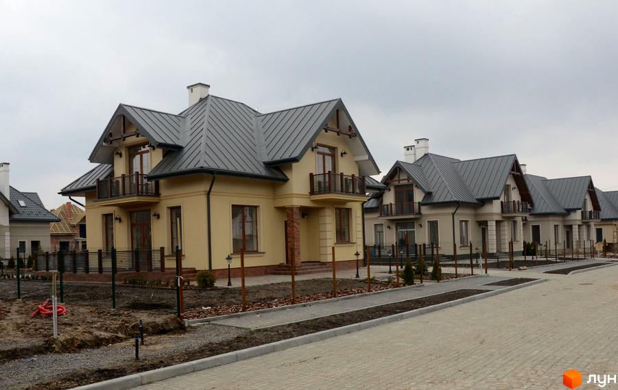 Фото Котеджного містечка Провесінь: двоповерхові будинки з сірими дахами та балконами. Навколо будинків облаштована прибудинкова територія.