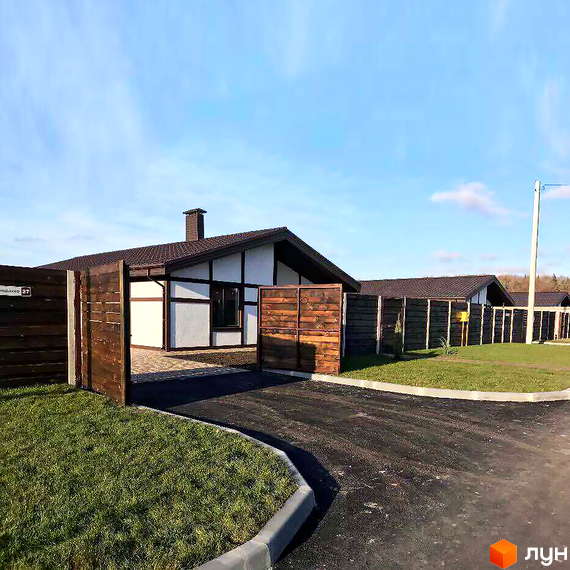 Котеджне містечко Європейський квартал. Одноповерховий будинок з коричневою покрівлею та білими стінами. Перед будинком газон та асфальтована дорога.