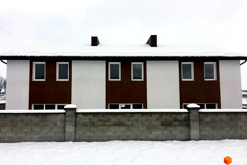 Зовнішній вигляд таунхаусів „Сонячна Долина“: білі та коричневі фасади, сніг на даху та навколо будинку. Сіра цегляна огорожа.