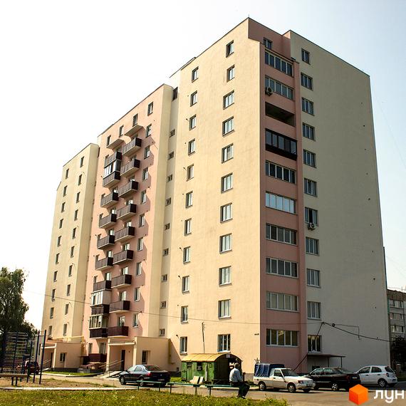 Житловий комплекс Нове Життя - висотна багатоповерхівка з балконами та вікнами. На прибудинковій території розташовані автомобілі та зелені насадження.