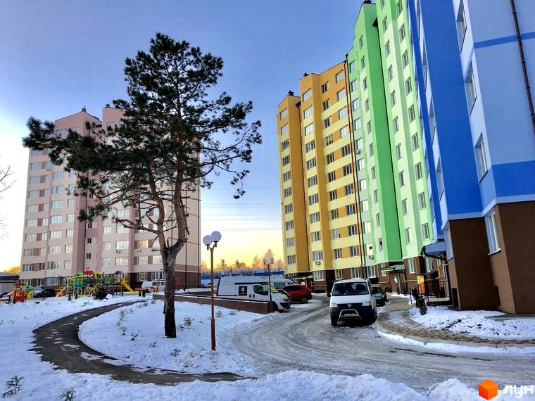 Житловий комплекс 4 Карата у Києві. Новобудова з різнокольоровими фасадами та прибудинковою територією, засніженою взимку.