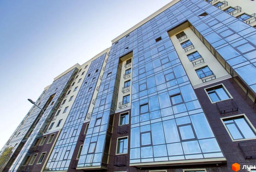 Зовнішній вигляд будинку Житлового комплексу Дванадцята Перлина з великими вікнами та балконами. Фасад оздоблений у світлих та темних тонах.