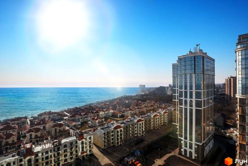 Вид на висотний будинок ЖК Дев'ятнадцята перлина з видом на море. Навколо будинку розташовані малоповерхові будинки з червоними дахами.