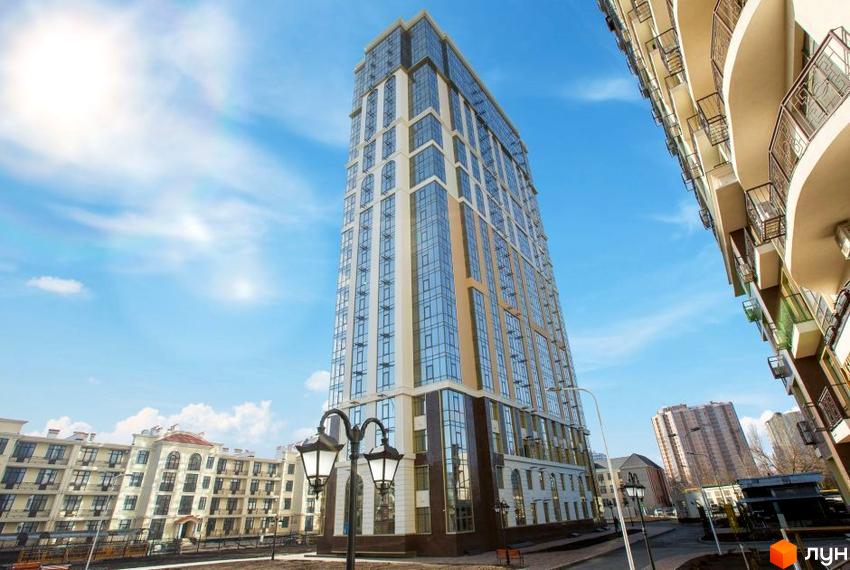 Висотна будівля ЖК Дев'ятнадцята перлина з великими вікнами на фоні блакитного неба. На передньому плані ліхтарі та доглянута прибудинкова територія.