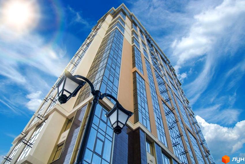 Висотна будівля ЖК Дев'ятнадцята перлина з скляними фасадами на фоні блакитного неба. На передньому плані ліхтар.