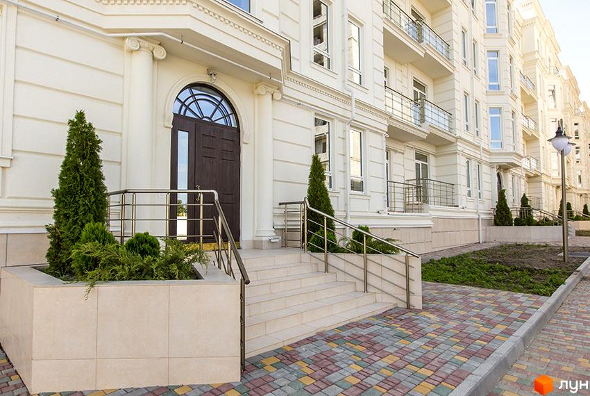 Житловий комплекс Двадцять третя Перлина має світлий фасад з арковим входом та балконами. Перед будинком розташовані сходи з поручнями та доріжка з кольорової плитки.