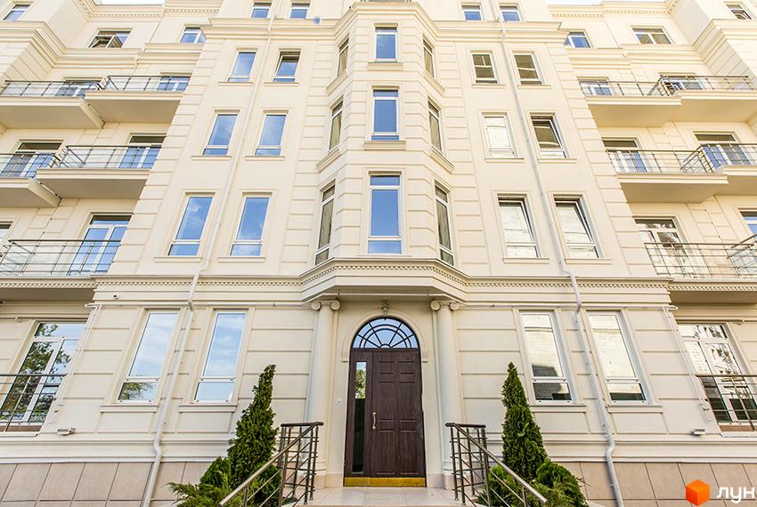 Фасад житлового комплексу Двадцять третя Перлина з балконами та вікнами. Біля входу розташовані зелені насадження та сходи.