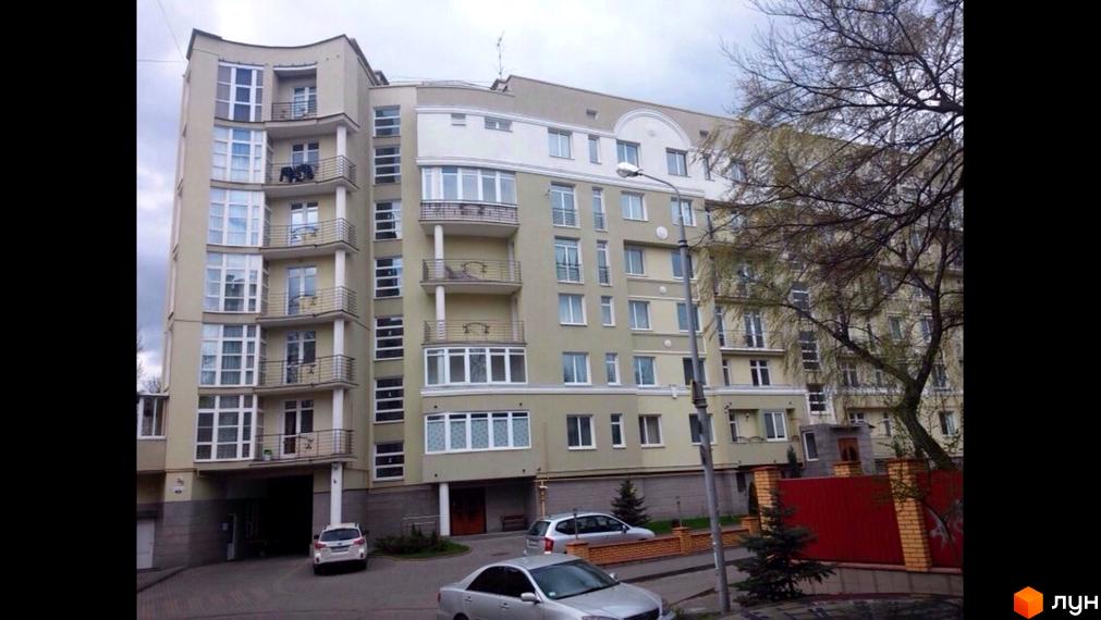 Фасад багатоповерхового будинку на вулиці Конотопській, 12. Зовнішній вигляд новобудови з балконами та великою кількістю вікон. Прибудинкова територія з деревами та автомобілями.