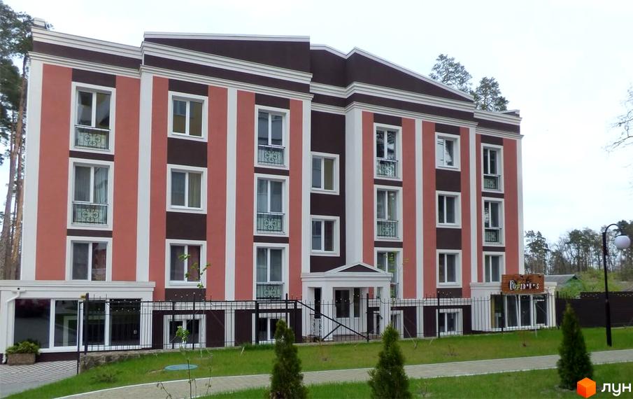 Фасад новобудови на вул. Антонія Михайлівського з червоними та коричневими смугами. Прибудинкова територія з зеленими насадженнями та доріжками.