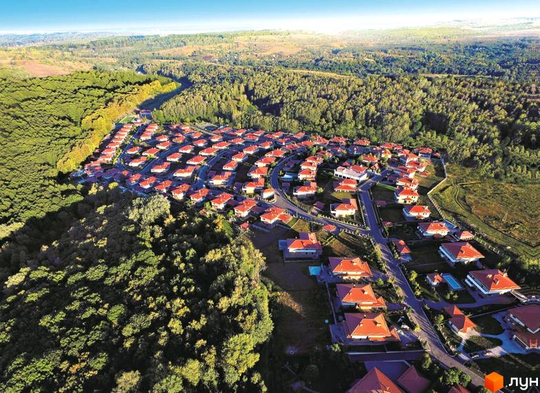 Вид зверху на Котеджне містечко Маєток. Перлина Італії з будинками з червоними дахами. Навколо комплексу ліс та доглянута територія.