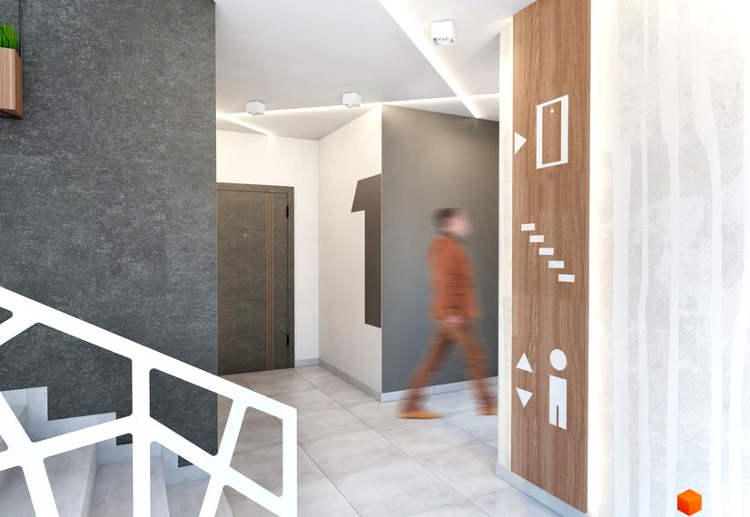 Вхідний хол Житлового комплексу Басів схил з сірою стіною, світлою плиткою та навігаційними знаками. Видно сходи з білими поручнями.