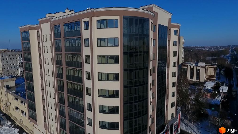 Зовнішній вигляд житлового комплексу Арена з багатоповерховими будинками та скляними фасадами. Навколо видно засніжену територію та міський пейзаж.