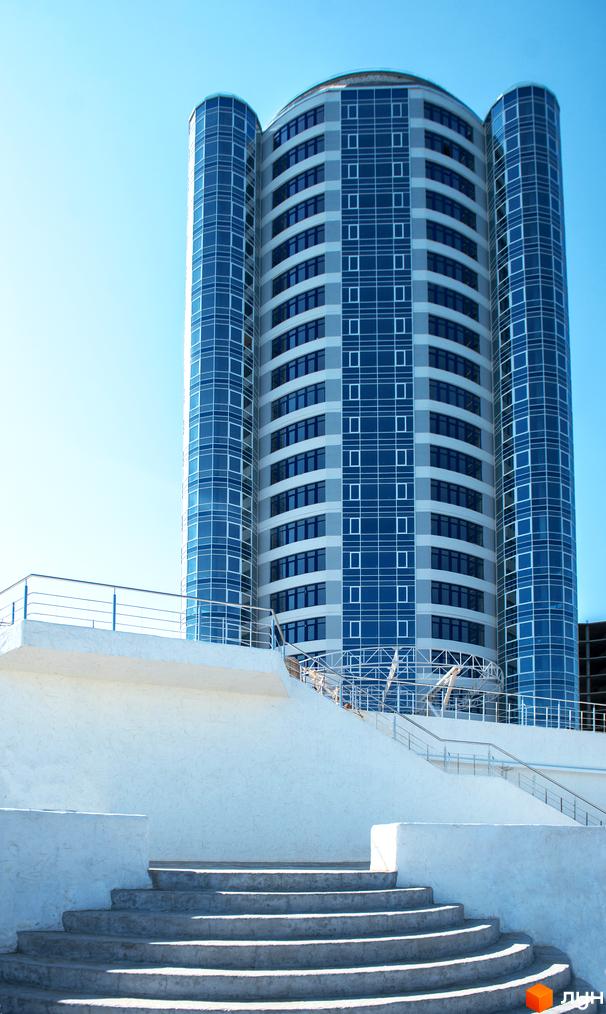 Житловий комплекс Морська симфонія з сучасною архітектурою та прибудинковою територією, що включає сходи та огорожу.