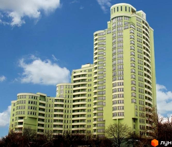 Житловий комплекс на просп. Науки, 80а/73 з зеленою фасадною частиною та балконами. Прибудинкова територія з деревами та облаштованими зонами відпочинку.