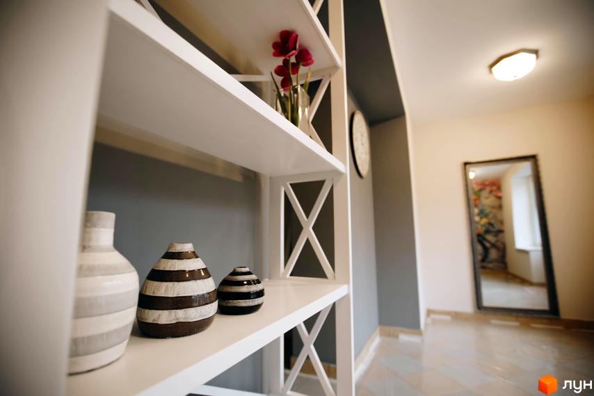 Житловий комплекс Comfort Club. Інтер'єр з білими полицями, декорованими вазами та квітами, та дзеркалом у коридорі.