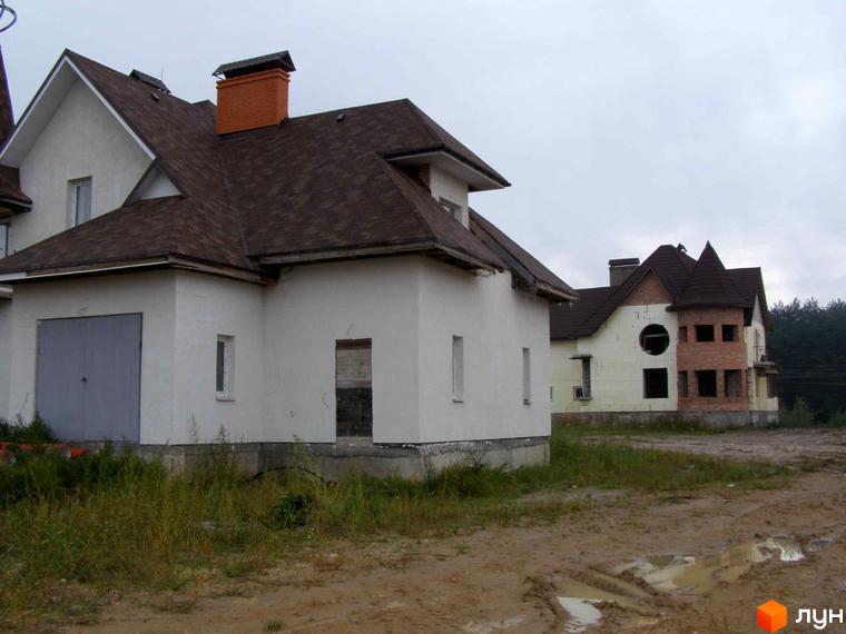 Будинок житлового комплексу КМ Злата Рудня з черепичним дахом та прибудинковою територією, що потребує озеленення.