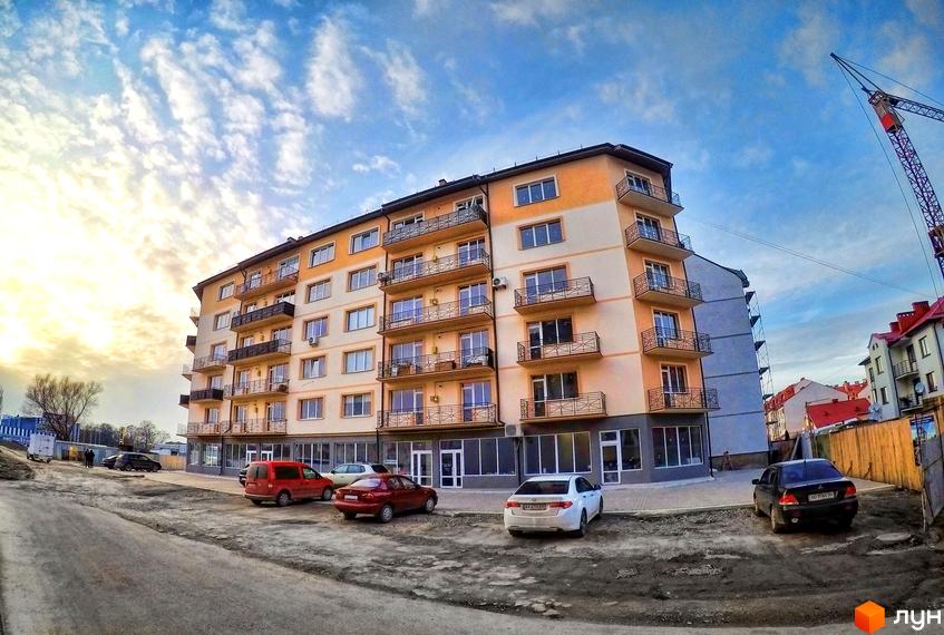 Житловий комплекс Климпуша: багатоповерхова новобудова з балконами та паркуванням біля будинку. Зовнішній вигляд будівлі та прибудинкової території.