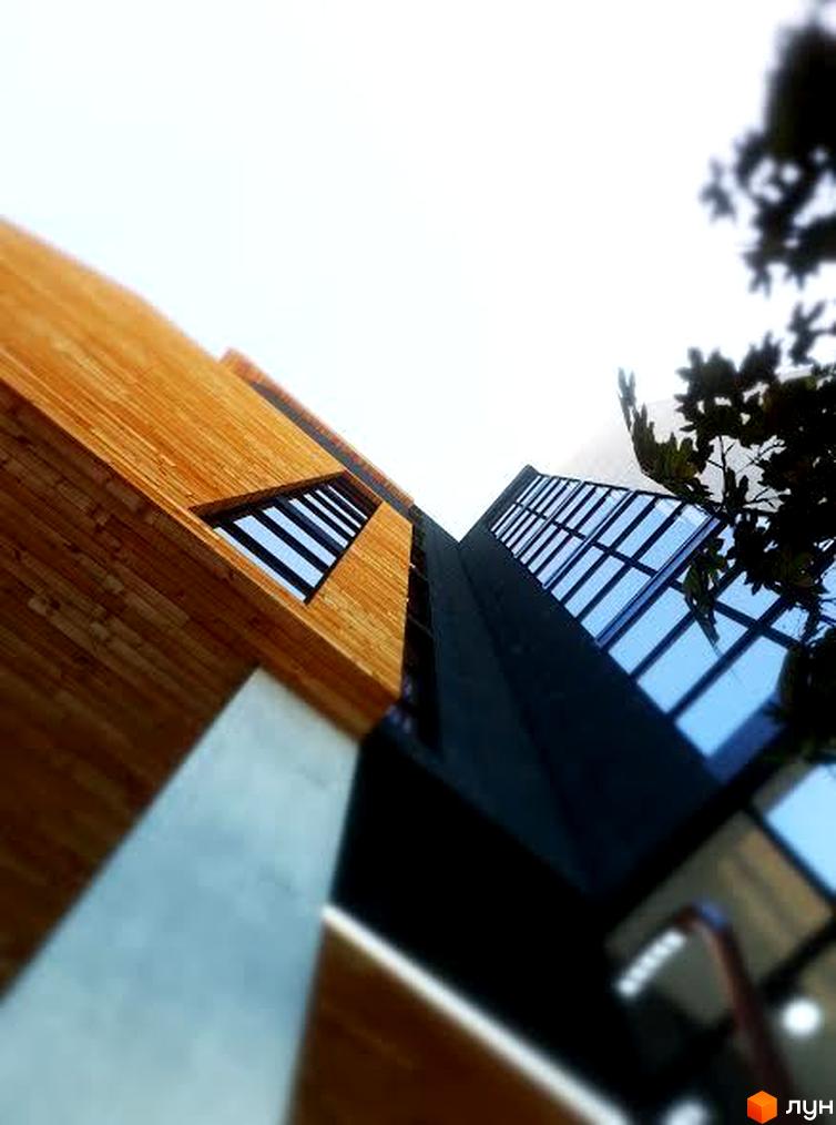 Клубний будинок „На Личаківській“ з дерев'яним фасадом та скляними вікнами. Зовнішній вигляд новобудови з перспективою знизу вгору.