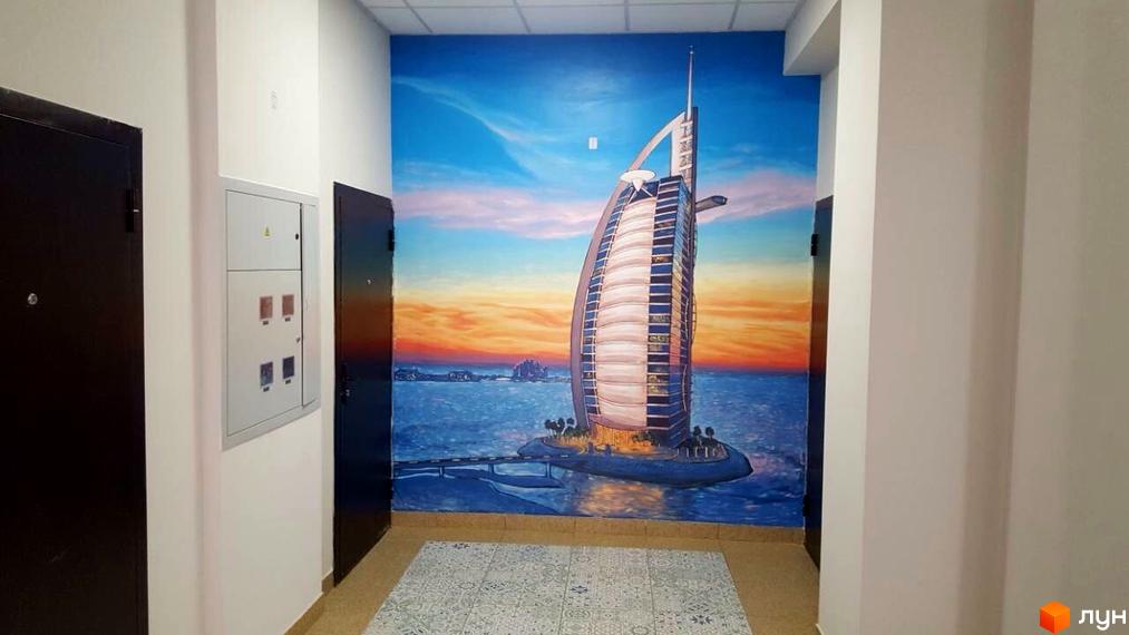 Фото фасаду житлового комплексу Comfort Club з мальовничим краєвидом Дубая на стіні. Опис новобудови з унікальним дизайном.