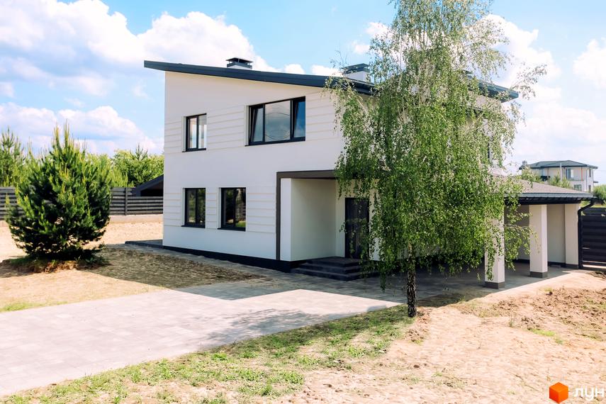 Білий двоповерховий будинок з чорним дахом та вікнами, прибудинкова територія з деревами та вимощеною доріжкою. White Villages.