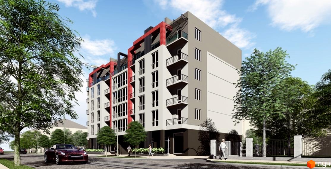 Зовнішній вигляд житлового комплексу Краківський з червоними та сірими фасадами, балконами та великими вікнами. Навколо новобудови дерева та вулиця з автомобілями.