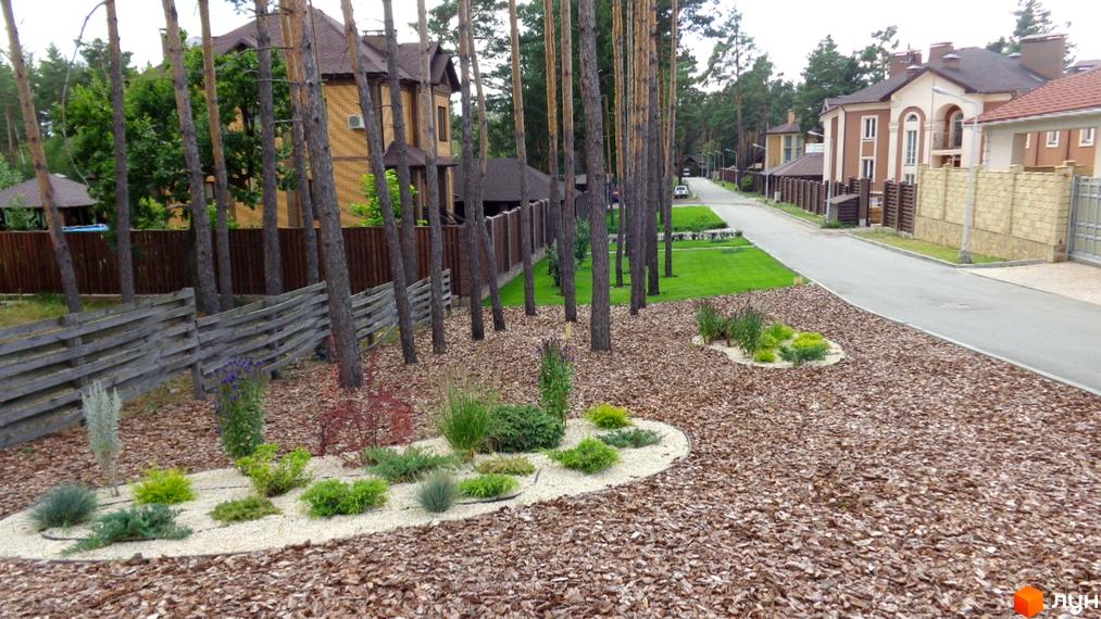 Котеджне містечко Green Wood club: цегляний будинок з коричневим дахом та прибудинковою територією з деревами та ландшафтним дизайном.