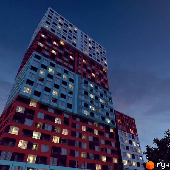 Житловий комплекс А12 на Симоненка – яскрава новобудова з різнокольоровими фасадами та безліччю вікон. Будинок має незвичайну архітектуру, що привертає увагу на тлі вечірнього неба.