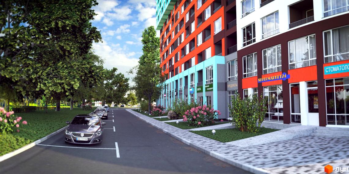 Житловий комплекс А12 на Симоненка: багатоповерхівка з фасадами в оранжевих та блакитних тонах, магазинами на першому поверсі. Навколо дерева та парковка.