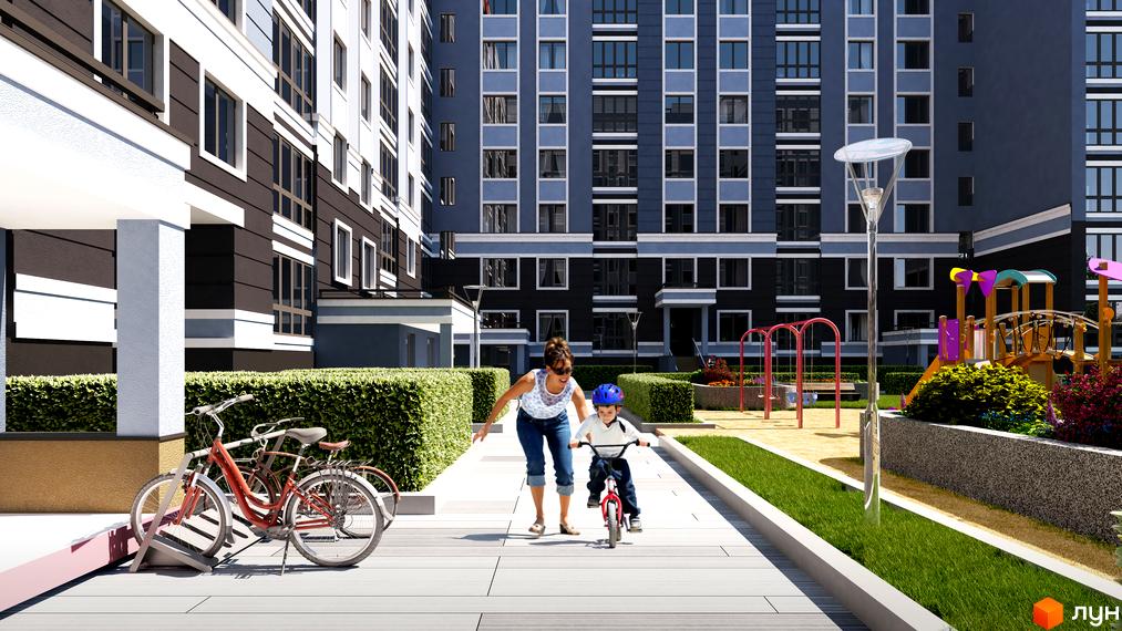 Багатоповерхові будинки Житлового комплексу Idilika з темно-сірими та білими фасадами. На прибудинковій території дитячий майданчик, зелені насадження та велопарковка.