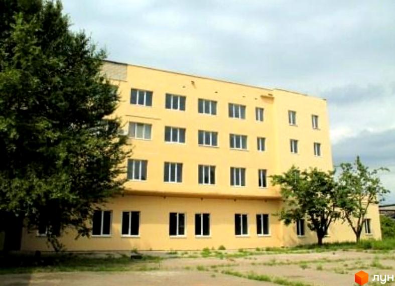 Житловий комплекс на Бериславському шосе, 2б. Жовтий будинок з великою кількістю вікон, перед будинком зелена трава.