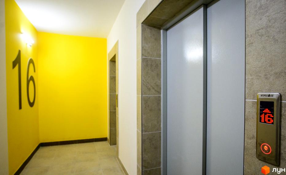 Житловий комплекс Відрадний: яскравий жовтий коридор з номером 16 та дверима ліфта. Зовнішній вигляд новобудови.