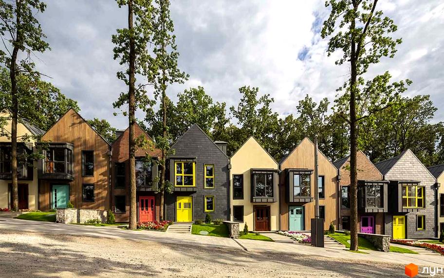 Котеджне містечко Oak Grove Town: фасади будинків з різними матеріалами та яскравими дверима. Територія з доріжками, газонами та високими деревами.