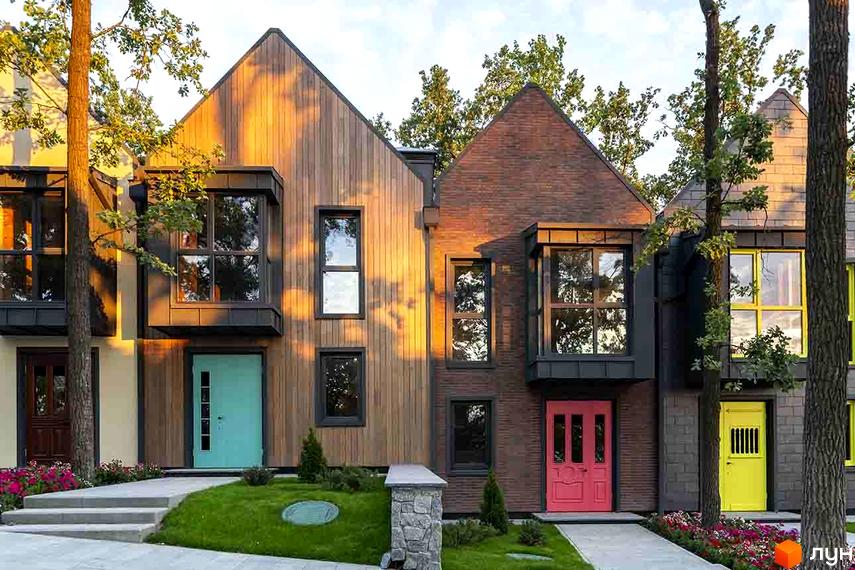 Котеджне містечко Oak Grove Town: фасади будинків з дерева, цегли та темної плитки, вікна з панорамним склінням. Доглянуті газони, квіти та дерева біля входів.