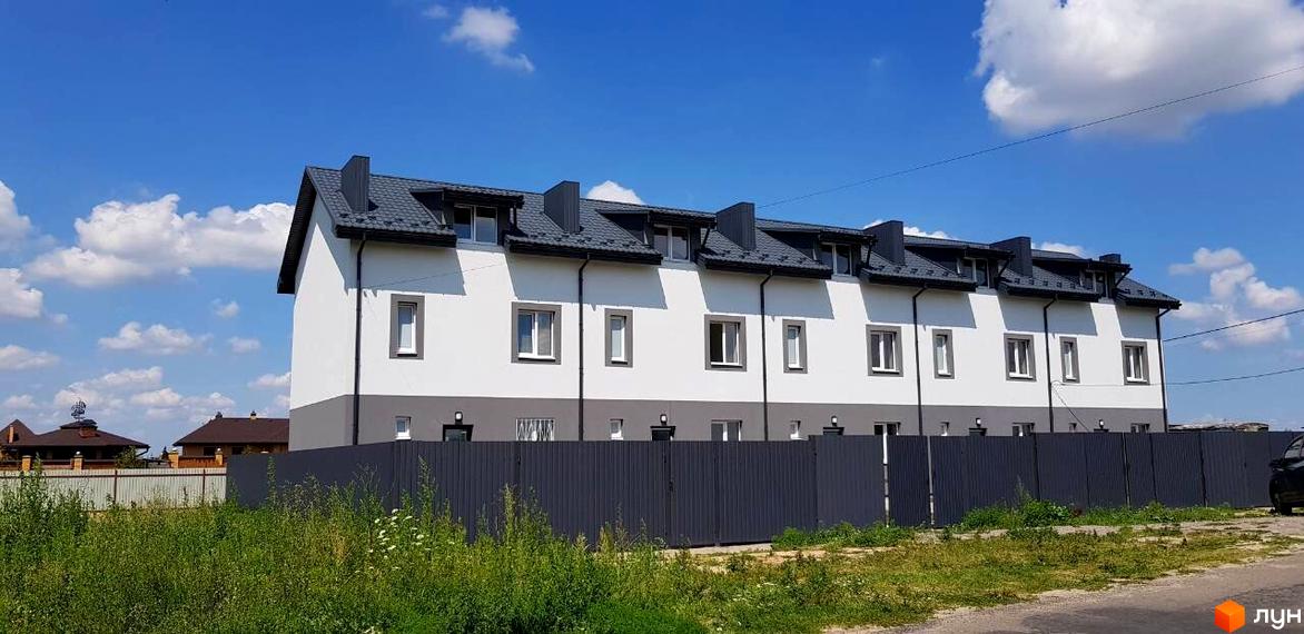 Таунхауси HarmonyBud: ряд білих будинків із сірими акцентами та темним дахом. Перед фасадом розташована огорожа та зелена ділянка.