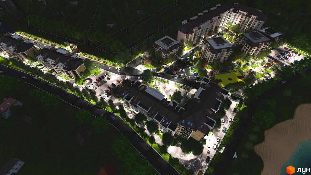 Нічний вигляд житлового комплексу Гранд Парк з освітленою територією та парковкою. Сучасна архітектура будинків та доглянута прибудинкова територія.