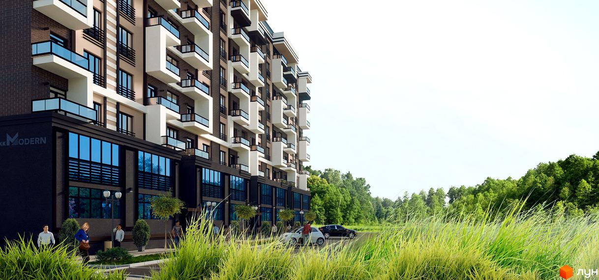 Житловий комплекс Modern з багатоповерховим фасадом у коричневих та темних тонах, білими балконами та великими вікнами. Поруч з будинком зелена прибудинкова територія, дорога та ліс на задньому плані.