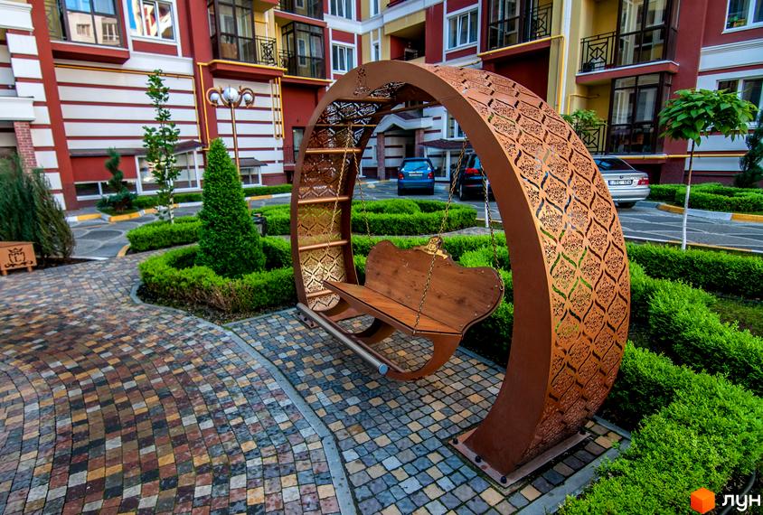 Житловий комплекс Версаль Парк. Прибудинкова територія з дизайнерськими гойдалками та зеленню.