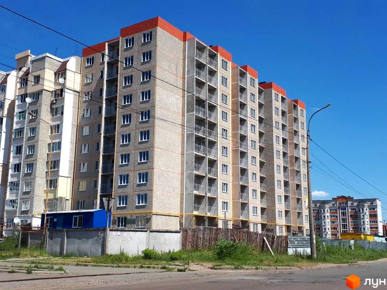 Фото фасаду багатоповерхового будинку Житлового комплексу на вул. Красносільського. Навколо будинку видно тротуар, дорогу та зелені насадження.