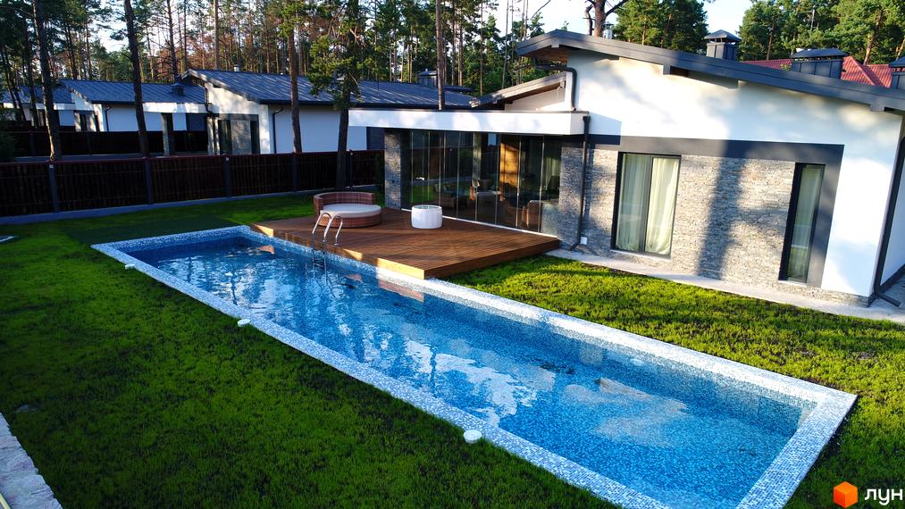 Зовнішній вигляд котеджу з басейном та терасою. КМ Хвойний квартал: котеджі з панорамними вікнами та доглянутою прибудинковою територією.