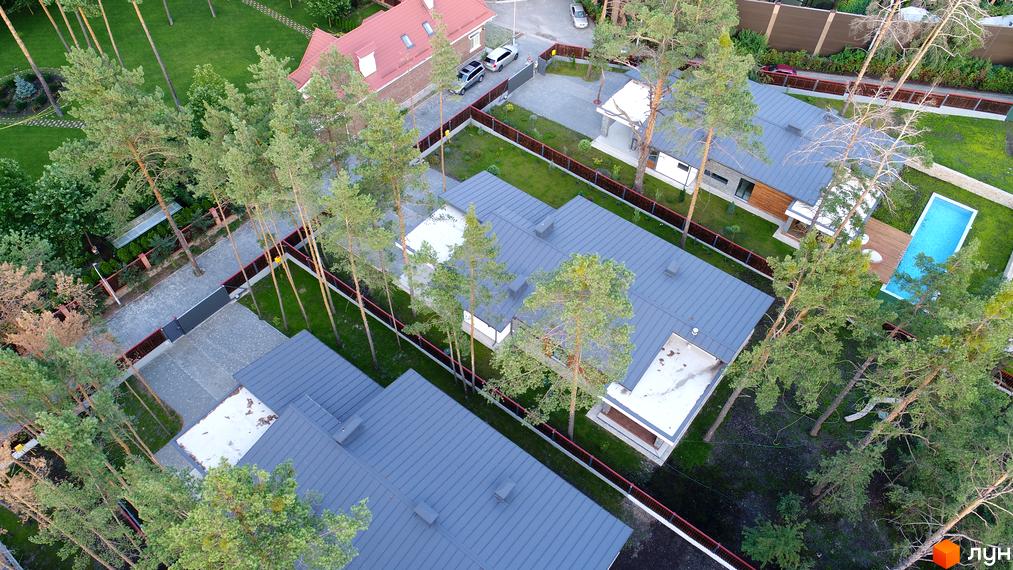 Вид зверху на Котеджне містечко Хвойний квартал. Будинки з сірими дахами та доглянутою територією, включаючи басейн та зелені насадження.