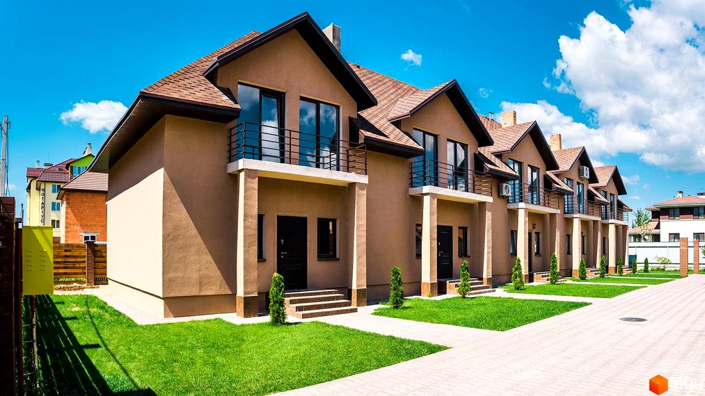 Зовнішній вигляд будинків на вулиці Дорошенка, 7. Двоповерхові будівлі з балконами та зеленими газонами перед входом.