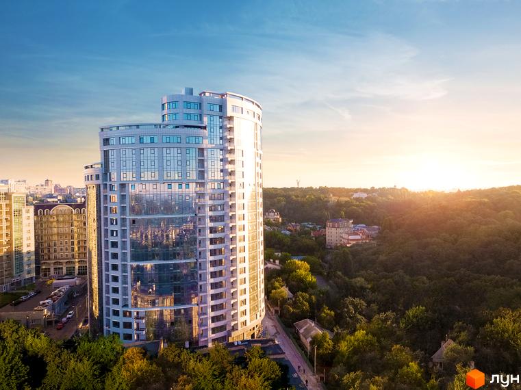 Житловий комплекс Busov Hill – висотна будівля з панорамним склінням та вигнутим фасадом. Навколо зелена зона та інші будинки.